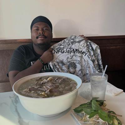 Guest with a large bowl of soup, holding a superhero themed shirt.