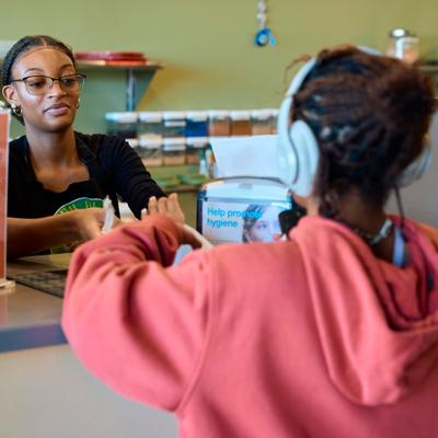 Customer being served at the counter by the staff member.