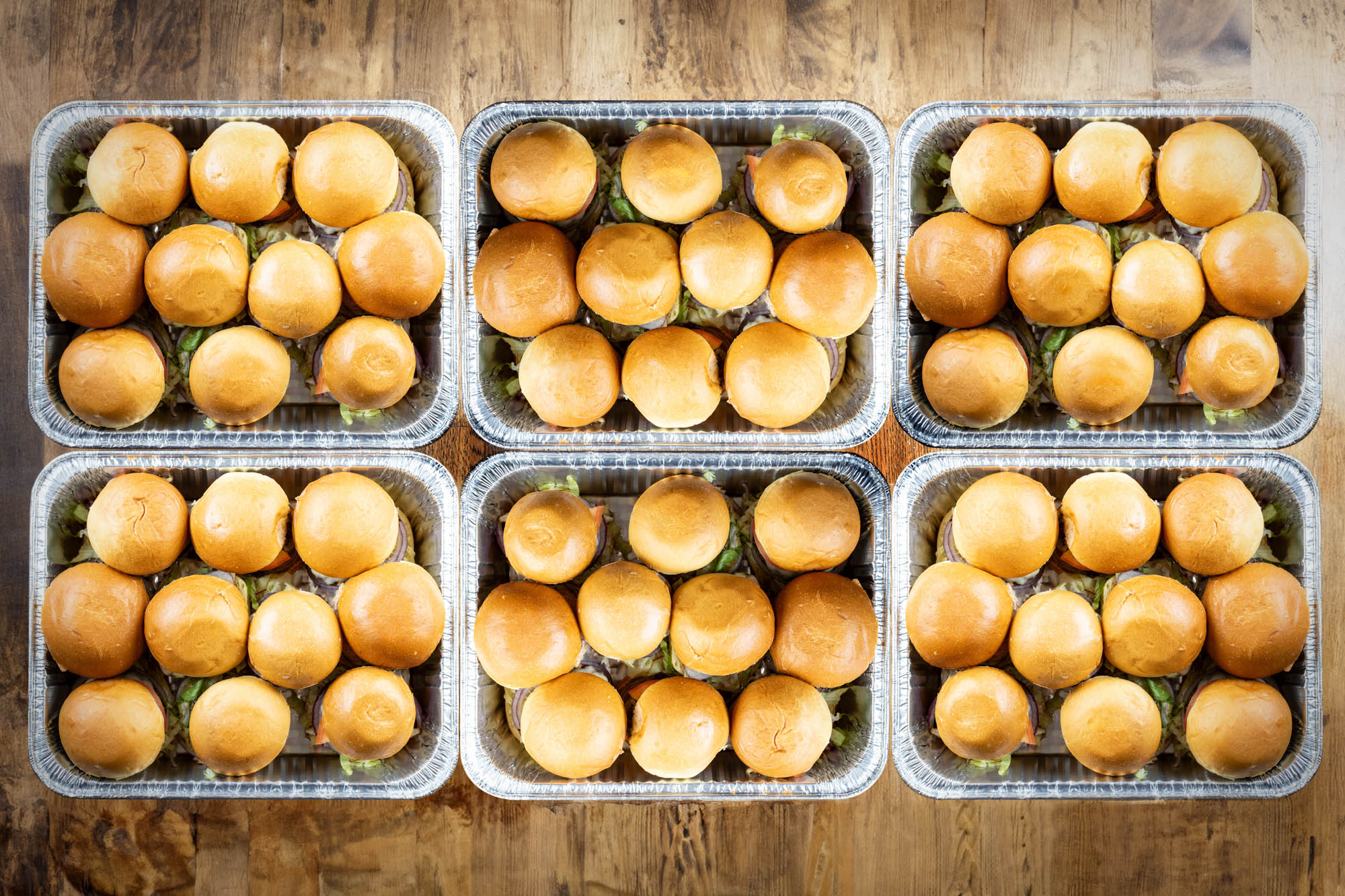 Six trays of Speedy's Burgers from our catering menu.