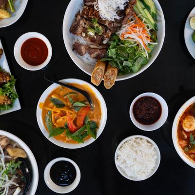 Multiple dishes served with rice and sauces on table.