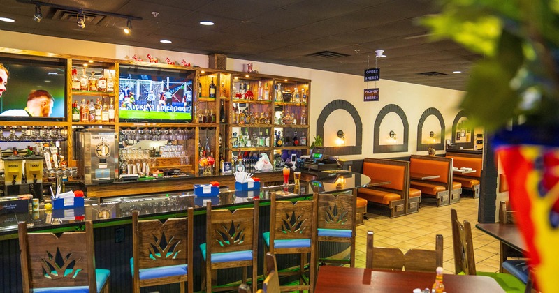 Interior, seating area, bar with bar stools, seating booths in the back