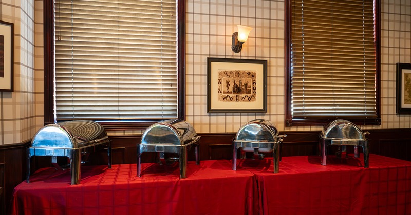 Buffet setup with stainless steel chafing dishes on a red tablecloth