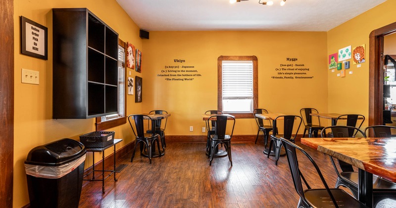 Interior, tables and chairs, large shelf on the left, paintings,  decorative writings on the wall