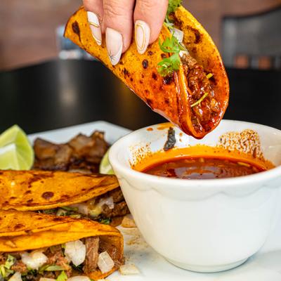 Birria taco dipped in consomme.