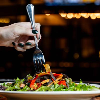 Hand taking a bite of Street Corn Taco Salad with a fork.