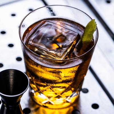 Amber-colored cocktail with lemon peel garnish.