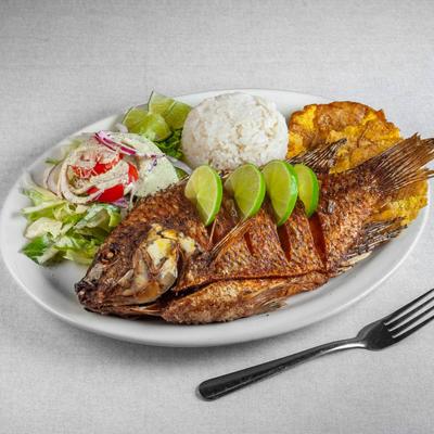 Whole fried tilapia served with vegetable rice, green plantains and house salad.