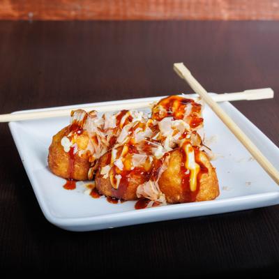 Takoyaki balls topped with bonito flakes, creamy mayo, and savory sauce.