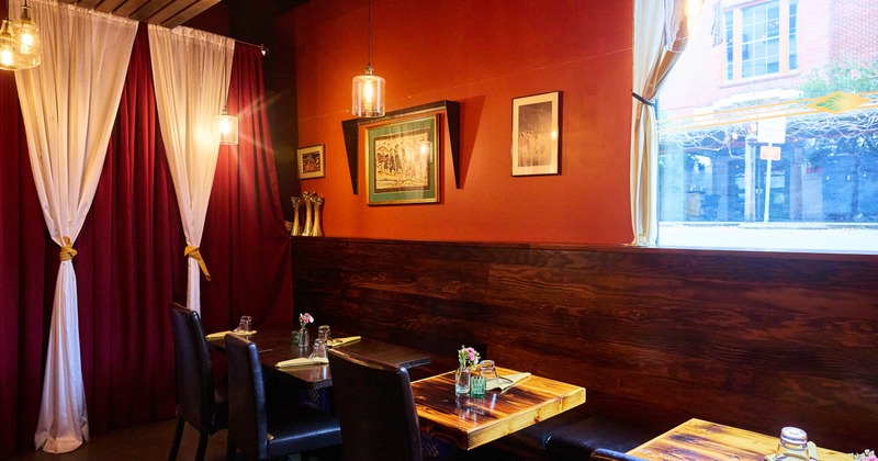 Interior, dining area, bench with wooden top tables and chairs, walls painted in red