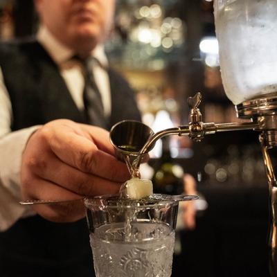 bartender pouring absinthe drink.