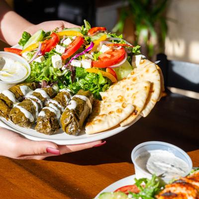 Veggie stuffed grape leaves served with Greek salad, pita, tzatziki and hummus.