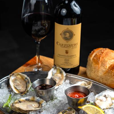 Fresh oysters served over ice with sauces and lemon wedges.