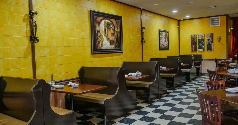 Interior, dining area, wooden seating booths with tables, framed painting on the walls