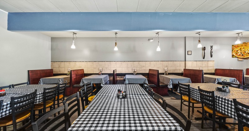 Interior of a restaurant with checkered tablecloths and booth seating