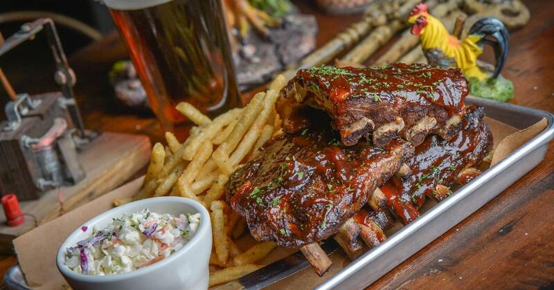 Ribs topped with sauce, served with fries