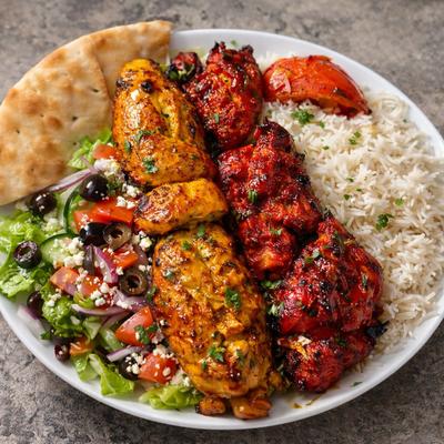 Chicken Combination Plate served with rice, Greek pita bread, roasted tomato and side salad.