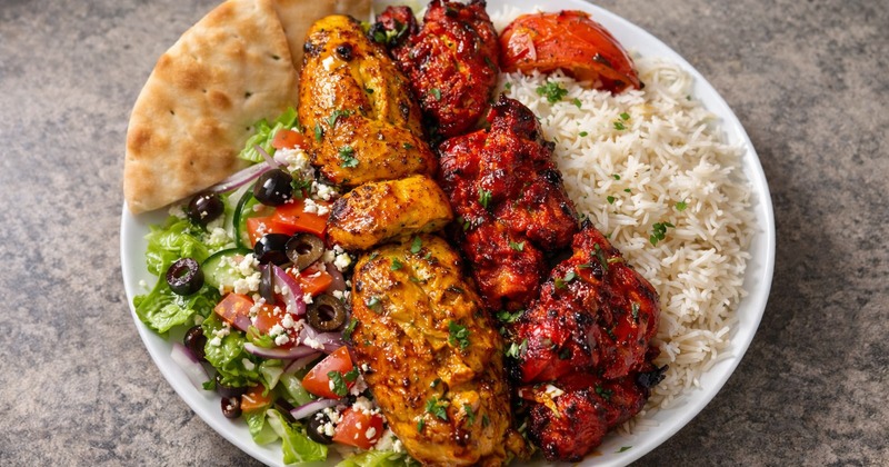 Chicken Combination Plate served with rice, Greek pita bread, roasted tomato and side salad