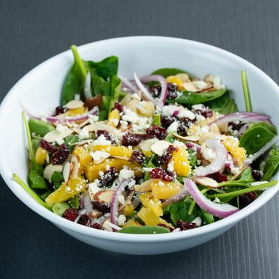 Cali Spinach Salad with nuts, citrus segments, dried cranberries, and red onion.
