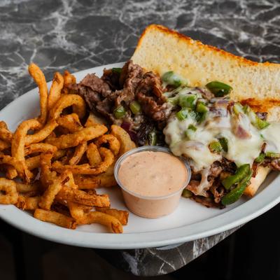 Wisconsin Cheese Steak on a Hoagie Roll, with fries.