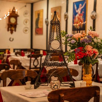 Elegant dining table with flowers and an Eiffel Tower shaped wine rack.
