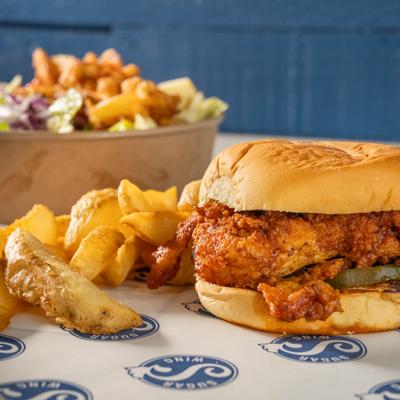 Crispy chicken sandwich with a side of potato wedges.