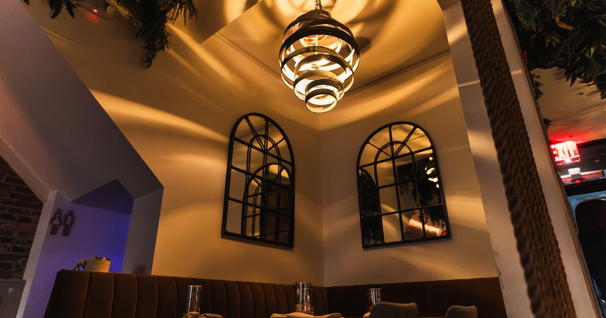 Diner area, table and chairs, view from down to chandelier and mirrors