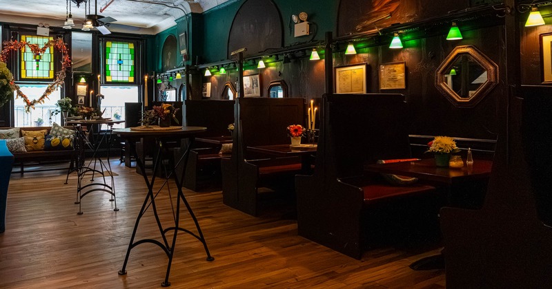 Cozy interior with wooden tables, chairs, framed art, and warm lighting