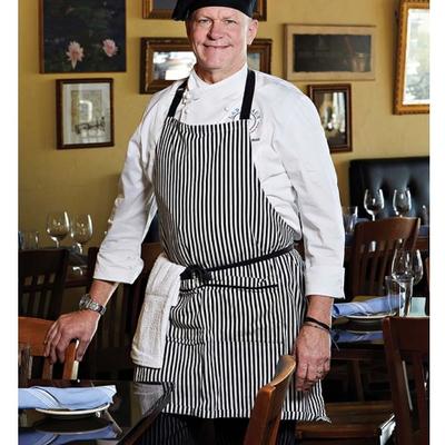 Chef posing for a shot in a dining room.