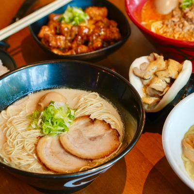 A variety of ramen bowls, pork belly, white rice, and side dishes.