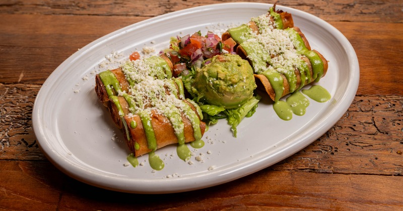 Taquitos served with cilantro crema, queso fresco and guacamole