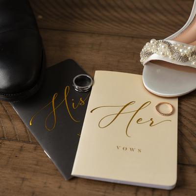 Shoes, vow books and wedding rings on a floor, close up