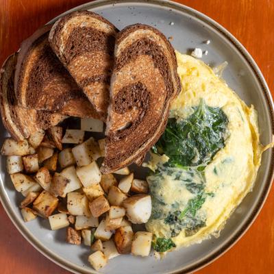 Spinach and feta omelet, with rye toast, and breakfast potatoes.