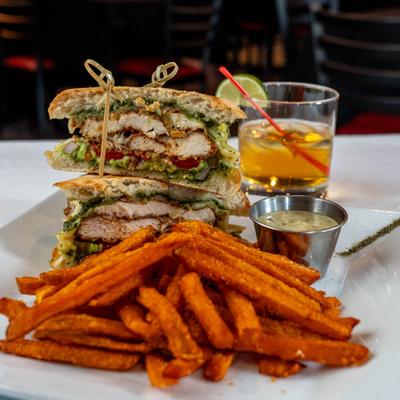 Chicken panini served with sweet potato fries and a cocktail.