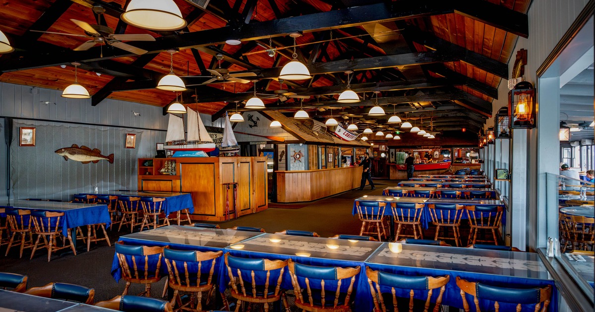 Interior of a nautical-themed restaurant with blue tablecloths on wooden tables