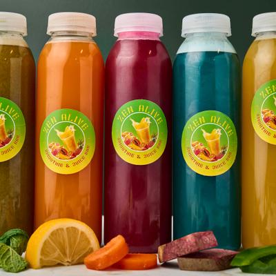 Various bottles of cold-pressed juices alongside fresh fruits and vegetables.