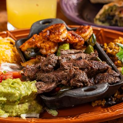 Skirt steak, served with rice, tortilla, onions, peppers, salsa, guacamole, and cheese.