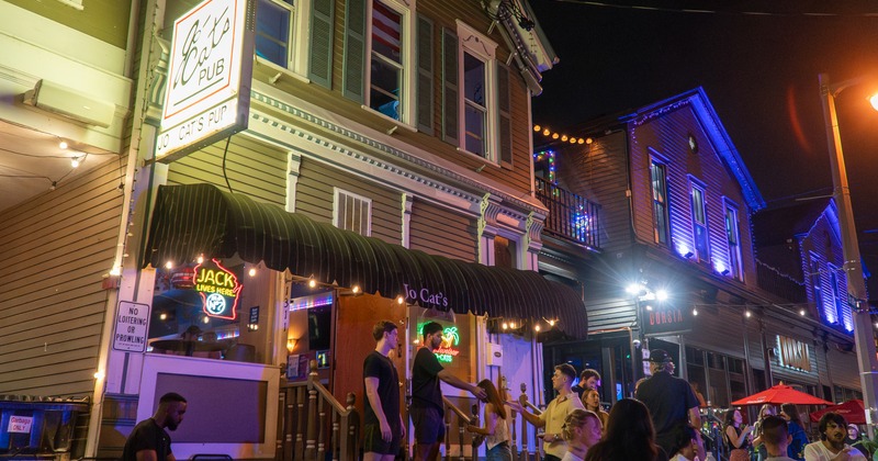 Exterior, side view to restaurant, sidewalk patio, people, night atmosphere
