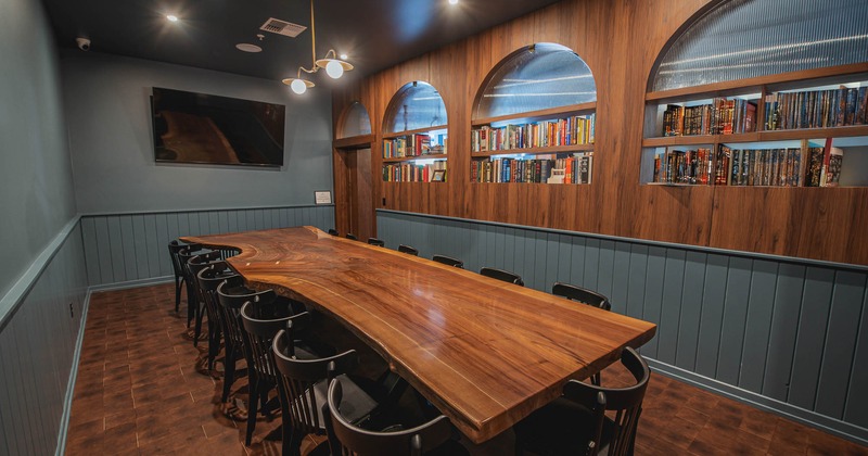 Conference room with a wooden table and chairs, a big TV on the wall