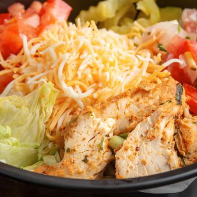 Grilled chicken salad, with cheese, lettuce, tomato, pickles, and onions.