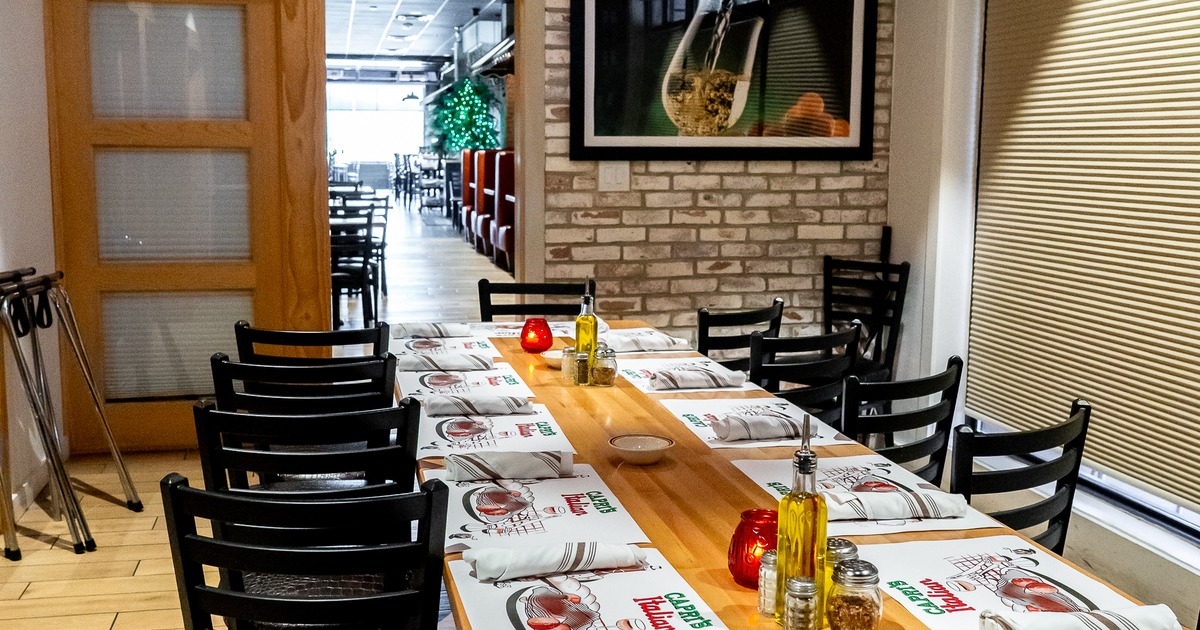 Long dining table set with chairs in a brick interior