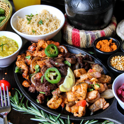 Grilled meat and mixed vegetables. spices, salad, rice and decorations on the side