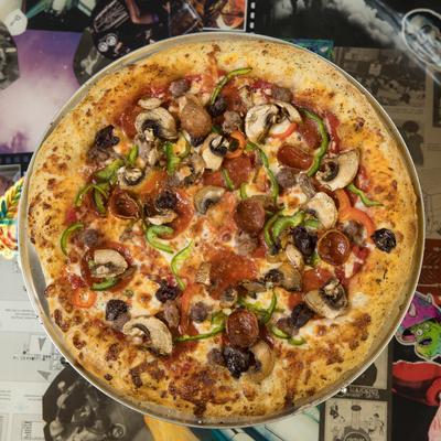 Deluxe Pizza with pepperoni, beef, ham, sausage, bell peppers, mushrooms, and olives.