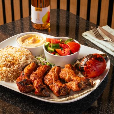 Pork ribs, with rice, salad, and hummus.