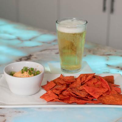 Pimento Cheese, with fried tortilla chips, and served with a glass of beer.