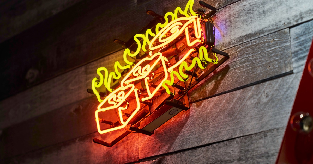 A decorative neon wall sign with fiery orange and yellow colors