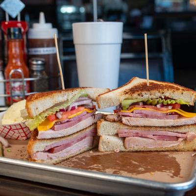 Club Sandwich, with turkey, ham, bacon, cheese, lettuce, tomato, and onion.