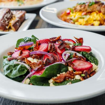 Strawberry and spinach salad with bacon, pecans, red onions, and crumbled cheese.