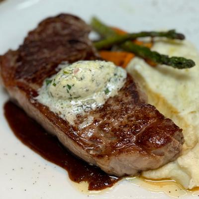 Brandt Beef New York Steak, mashed potatoes, roasted baby carrots & asparagus, compound butter.