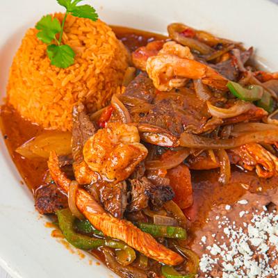 Chicken, steak, and shrimp Fajitas, served with rice, and refried beans.