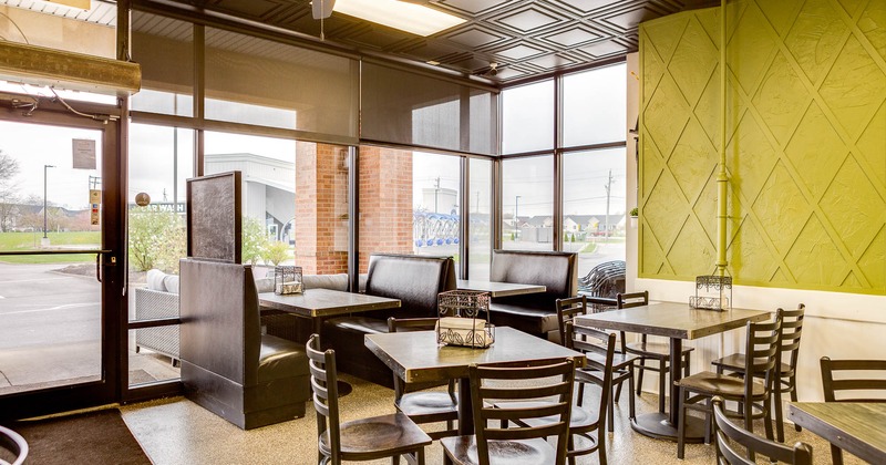 Interior, tables and chairs with restaurant booths in the back